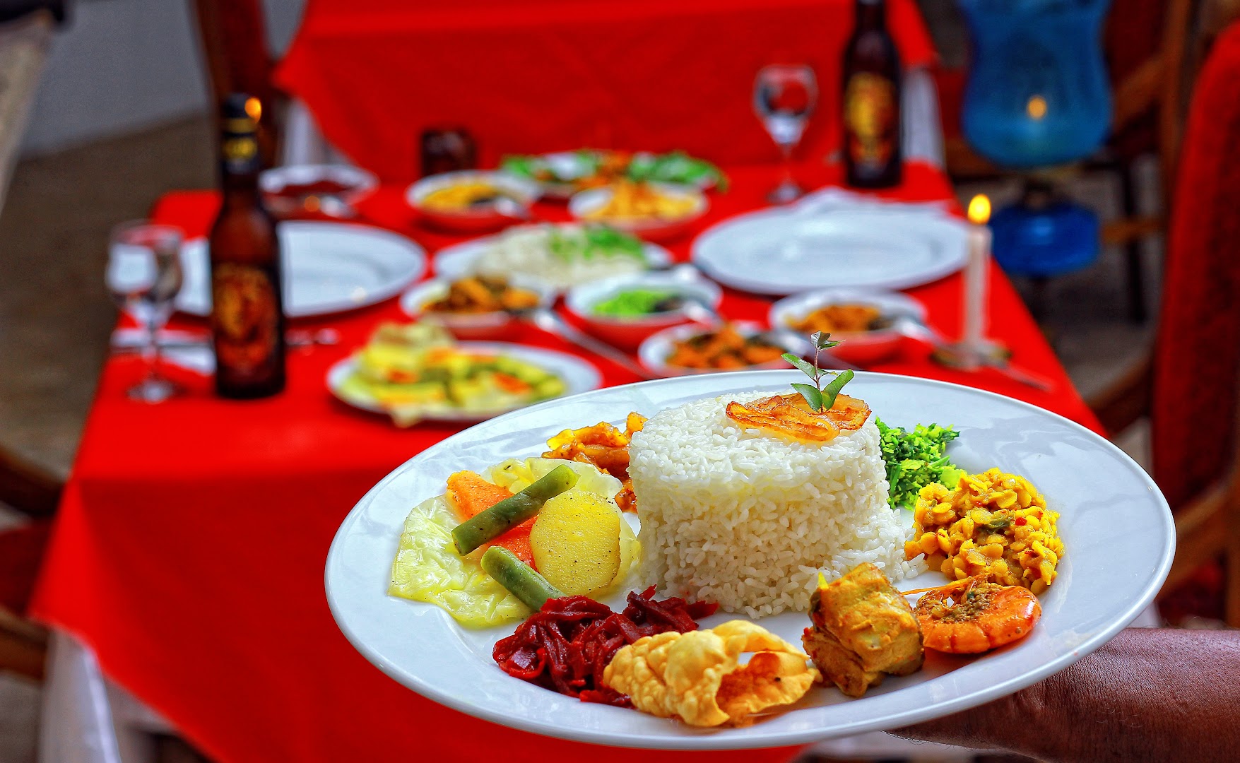 Sri Lankan rice and curry dishes served on a red dining table